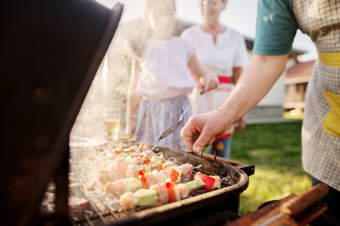 A charcoal grill with kebabs being cooked